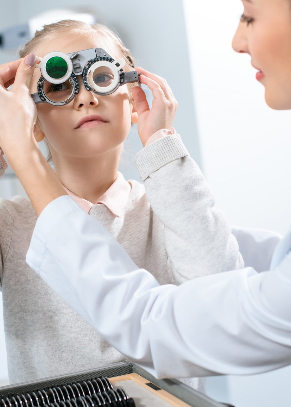 female-oculist-examining-kid-eyes-with-trial-frame-and-lenses.jpg